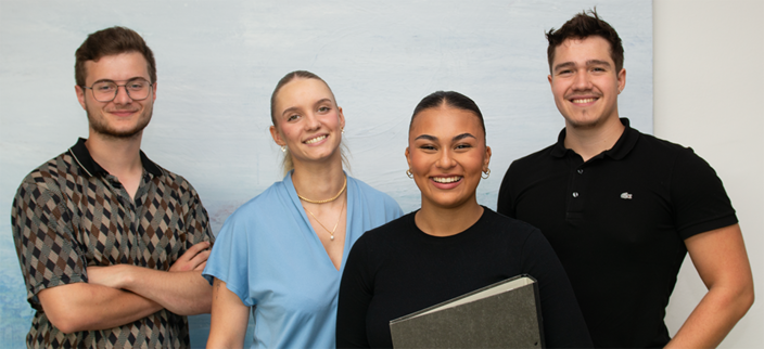 4 junge Menschen stehen zum Gruppenfoto und lachen 4 junge Menschen stehen zum Gruppenfoto und lachen