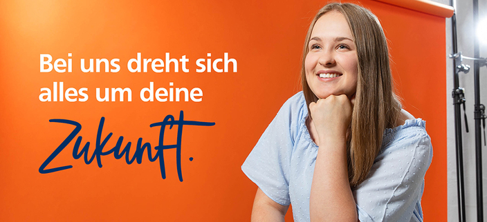 Junge lächelnde Person vor orangefarbenem Hintergrund, Bildaufschrift: Bei uns dreht sich alles um deine Zukunft. Junge lächelnde Person vor orangefarbenem Hintergrund, Bildaufschrift: Bei uns dreht sich alles um deine Zukunft.