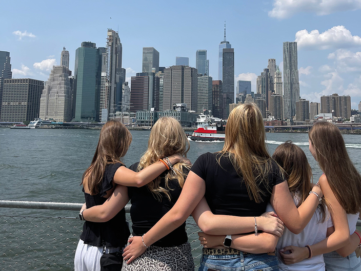 Kleine Gruppe junger Menschen schaut auf die Skyline von New York Kleine Gruppe junger Menschen schaut auf die Skyline von New York
