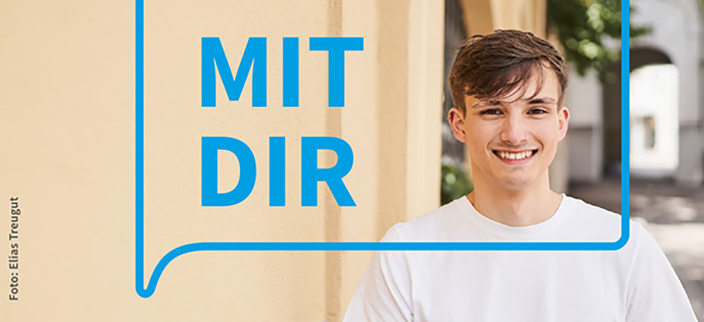Person lächelt in die Kamera, linksseitig der Slogan "MIT DIR" Person lächelt in die Kamera, linksseitig der Slogan "MIT DIR"