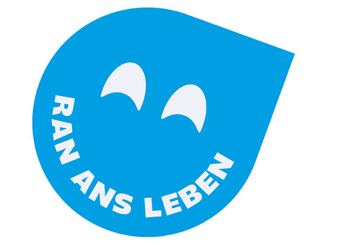 Lachender Smiley in der Form eines Tropfens mit dem Slogan "RAN ANS LEBEN" als Mund. Lachender Smiley in der Form eines Tropfens mit dem Slogan "RAN ANS LEBEN" als Mund.
