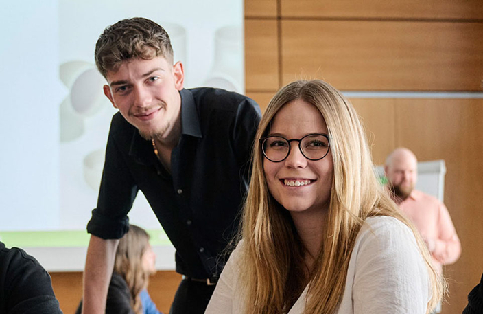Zwei junge Menschen lächeln in die Kamera Zwei junge Menschen lächeln in die Kamera