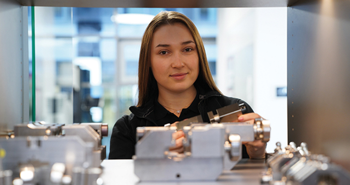 Junge Person mit einem Bauteil in der Hand Junge Person mit einem Bauteil in der Hand