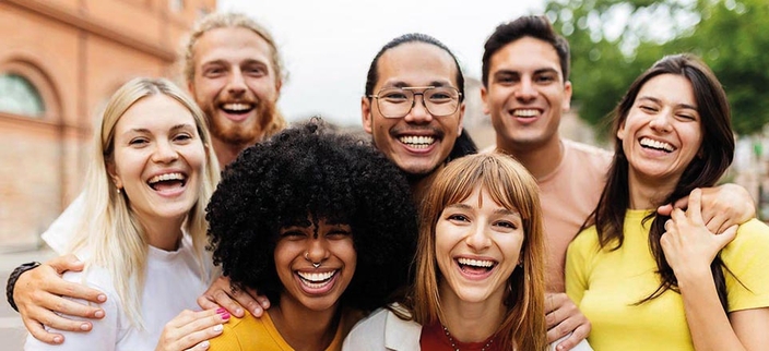 Gruppenbild von sieben jungen lachenden Menschen
