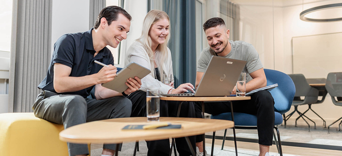3 Menschen besprechen sich an einem kleinen Tisch 3 Menschen besprechen sich an einem kleinen Tisch