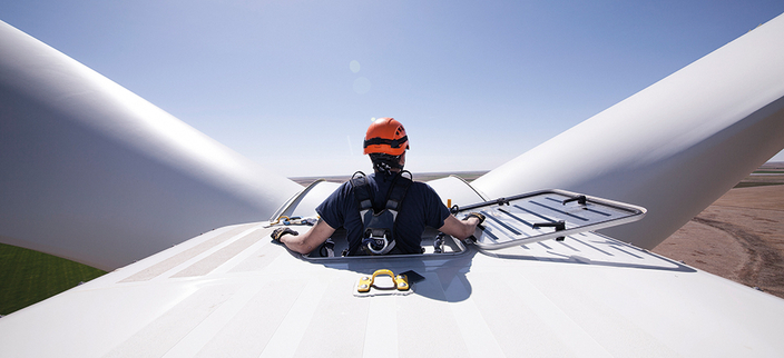 Mechatroniker mit Helm auf einer Windenergieanlage Mechatroniker mit Helm auf einer Windenergieanlage