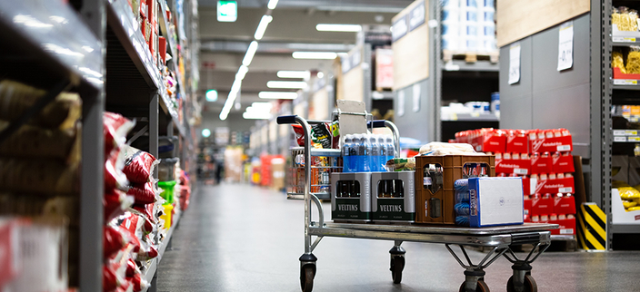 Vollgepackter Einkaufswagen in Einkaufshalle Vollgepackter Einkaufswagen in Einkaufshalle