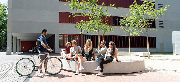 Personengruppe auf einer Sitzgelegenheit vor der Hochschule. Personengruppe auf einer Sitzgelegenheit vor der Hochschule.