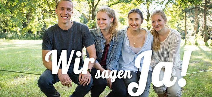 Vier Personen auf einer Slackline mit dem Slogan " Wir sagen Ja!" Vier Personen auf einer Slackline mit dem Slogan " Wir sagen Ja!"