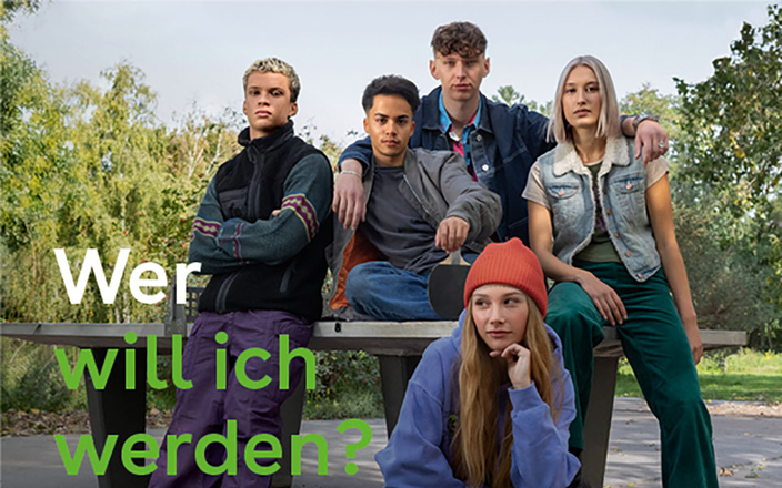 Fünf junge Personen sitzen auf und lehnen an einer Tischtennisplatte im Grünen, Bildaufschrift: Wer will ich werden?