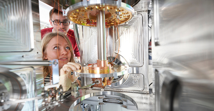 Junge Studenten schauen sich Experimentiergefäß an Junge Studenten schauen sich Experimentiergefäß an