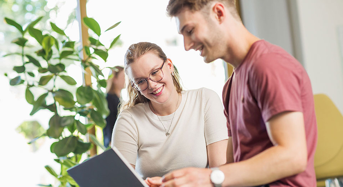 Zwei Personen schauen auf einen Laptop Zwei Personen schauen auf einen Laptop