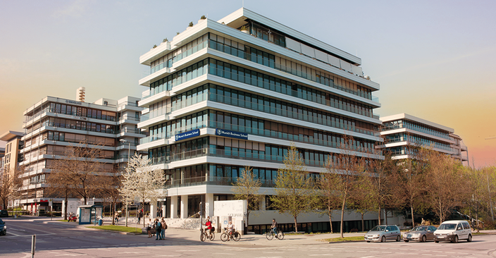 8-stöckiges Hochschulgebäude mit einigen kleineren Bäumen davor 8-stöckiges Hochschulgebäude mit einigen kleineren Bäumen davor