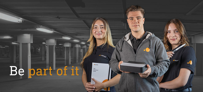 Drei Personen in der Arbeitskleidung der STEINEL GmbH. Linksseitig der Slogan "Be part of it"