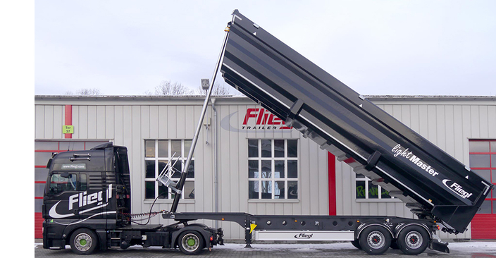 LKW mit Abkippfunktion vor Firmenhalle LKW mit Abkippfunktion vor Firmenhalle