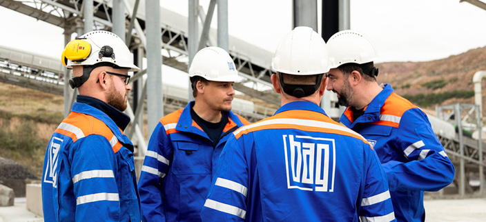 Gruppe männlicher Personen mit Schutzhelmen und Basalt AG Arbeitskleidung. Gruppe männlicher Personen mit Schutzhelmen und Basalt AG Arbeitskleidung.