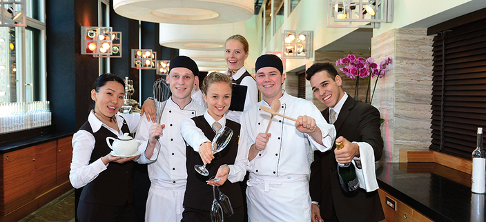 Sechs Auszubildende in Hotel und Gastronomie in entsprechender Arbeitskleidung Sechs Auszubildende in Hotel und Gastronomie in entsprechender Arbeitskleidung