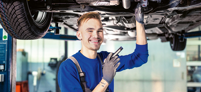 Mechaniker bei der Arbeit unter Fahrzeug Mechaniker bei der Arbeit unter Fahrzeug