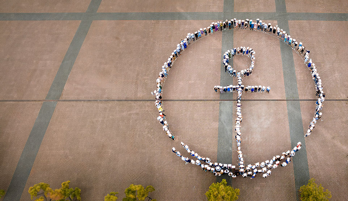 Mitarbeitende formen das Kühne + Nagel Logo auf einem Platz. Das Bild ist aus der Vogelperspektive. Mitarbeitende formen das Kühne + Nagel Logo auf einem Platz. Das Bild ist aus der Vogelperspektive.