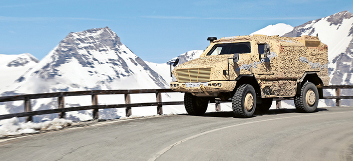 Offroadtruck auf einer Straße. Im Hintergrund sind verschneite Berge zu sehen Offroadtruck auf einer Straße. Im Hintergrund sind verschneite Berge zu sehen
