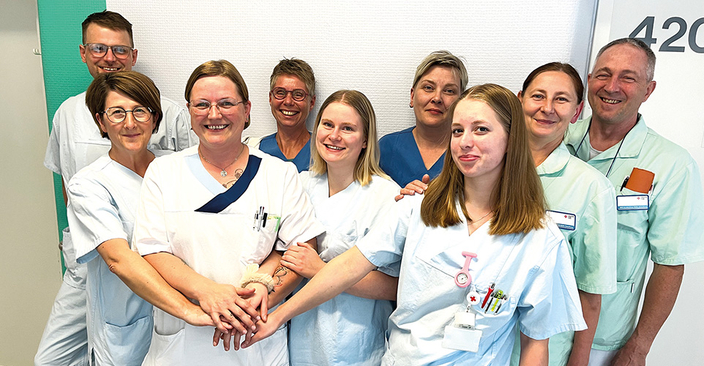 9 Pflegepersonen und Ärzte stehen zum Gruppenbild im Krankenhaus Flur 9 Pflegepersonen und Ärzte stehen zum Gruppenbild im Krankenhaus Flur