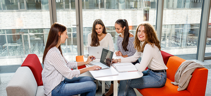Vierer Personengruppe sitzt zusammen an einem Tisch und liest in Büchern. Vierer Personengruppe sitzt zusammen an einem Tisch und liest in Büchern.