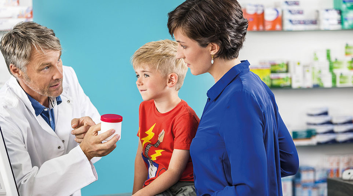 Apotheker berät eine Mutter und ihr Kind Apotheker berät eine Mutter und ihr Kind