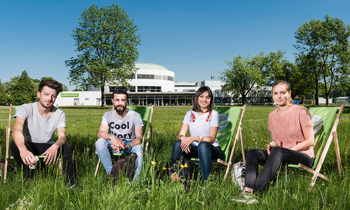 Vier Studierende in Liegestühlen auf der Wiese vor dem Gebäude der Hochschule Magdeburg-Stendal Vier Studierende in Liegestühlen auf der Wiese vor dem Gebäude der Hochschule Magdeburg-Stendal
