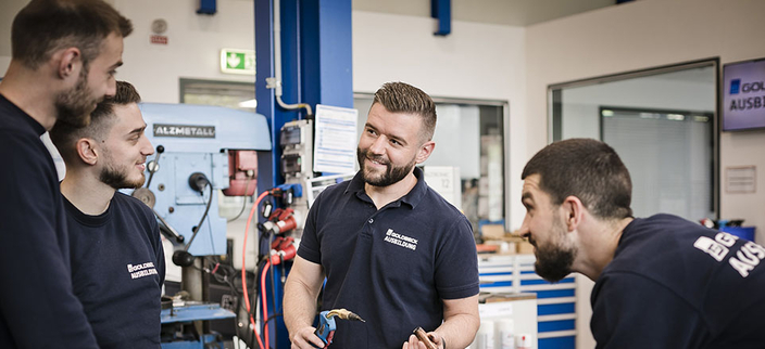 Vier Personen vor elektronischen Geräten. Vier Personen vor elektronischen Geräten.