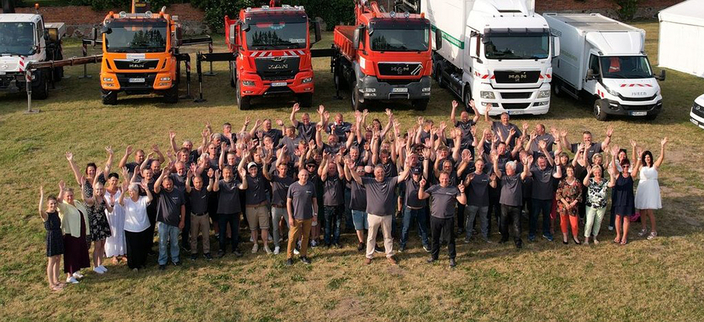 Große Personengruppe aus der Luft fotografiert. Im Hintergrund Dienstleistungsfahrzeuge. Große Personengruppe aus der Luft fotografiert. Im Hintergrund Dienstleistungsfahrzeuge.