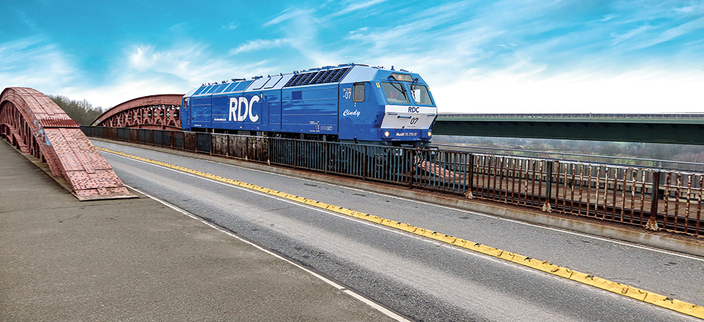 Eine Eisenbahn von RDC fährt über eine Brücke Eine Eisenbahn von RDC fährt über eine Brücke