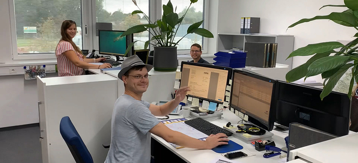 3 Mitarbeitende im Büro bei der Arbeit 3 Mitarbeitende im Büro bei der Arbeit