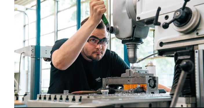 Mann mit Schutzbrille an Arbeitsgerät Mann mit Schutzbrille an Arbeitsgerät