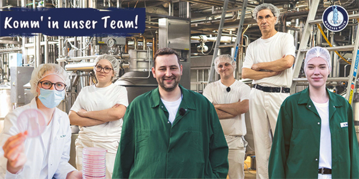 Sechs Mitarbeitende mit Schutzhauben in der Produktionsstätte, Bildaufschrift: Komm in unser Team! Sechs Mitarbeitende mit Schutzhauben in der Produktionsstätte, Bildaufschrift: Komm in unser Team!