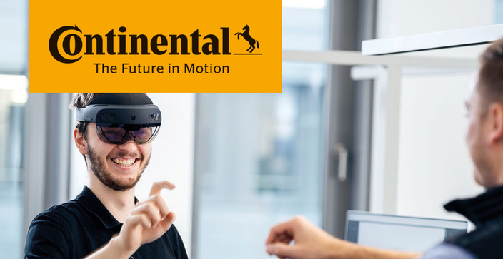 Eine Person trägt eine Virtual-Reality-Brille und lächelt, während sie mit der Hand eine Geste formt. Ihr gegenüber ist eine weitere Person zu sehen. In der linken oberen Ecke befindet sich das Continental-Logo mit dem Slogan „The Future in Motion