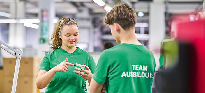 Zwei junge Menschen in grünen T-Shirts mit der Aufschrift "Team Ausbildung" im Gespräch Zwei junge Menschen in grünen T-Shirts mit der Aufschrift "Team Ausbildung" im Gespräch