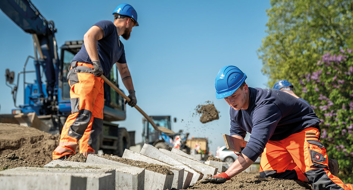 Zwei Bauarbeiter bei der Arbeit auf einer Baustelle Zwei Bauarbeiter bei der Arbeit auf einer Baustelle