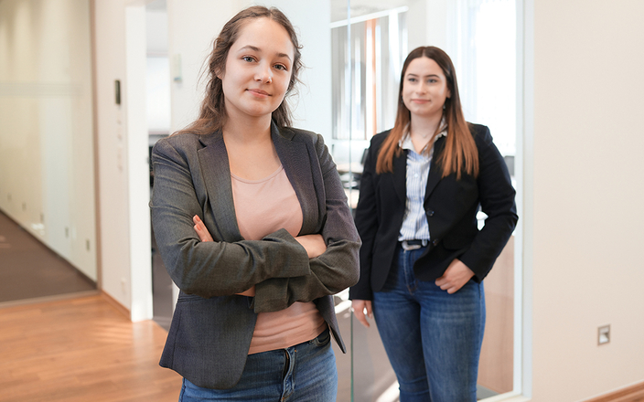 2 junge Frauen stehen in Büroflur 2 junge Frauen stehen in Büroflur