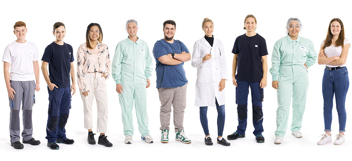 Freigestelltes Gruppenfoto von neun Auszubildenden aus verschiedenen Bereichen