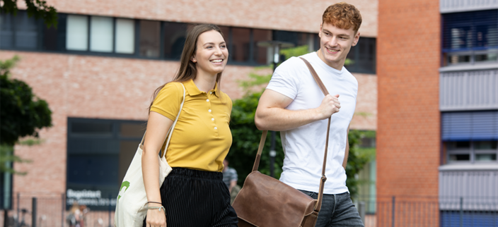 Zwei Studierende vor dem Hochschulgebäude