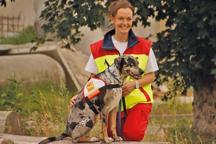 Mitarbeiterin des ASB zusammen mit einem Hund der Rettungshundestaffel