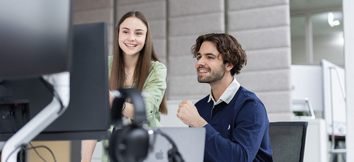 Zwei Personen vor einem Computer. Zwei Personen vor einem Computer.