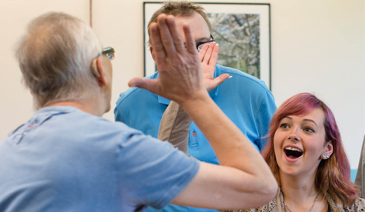 Älterer Herr beim High Five mit jüngerer Frau