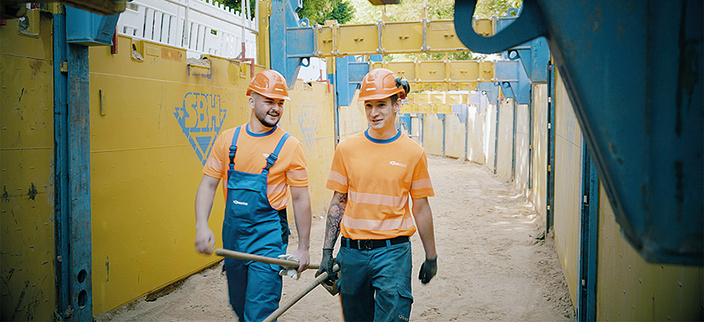 Zwei Menschen mit Helm auf einer Baustelle Zwei Menschen mit Helm auf einer Baustelle
