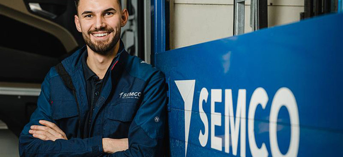 Mann vor Semco-Logo Mann vor Semco-Logo