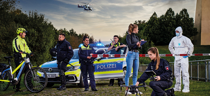Gruppenfoto von sieben Menschen aus verschiedenen Bereichen der Polizeidirektion Osnabrück, im Hintergund ein Helikopter am Himmel Gruppenfoto von sieben Menschen aus verschiedenen Bereichen der Polizeidirektion Osnabrück, im Hintergund ein Helikopter am Himmel