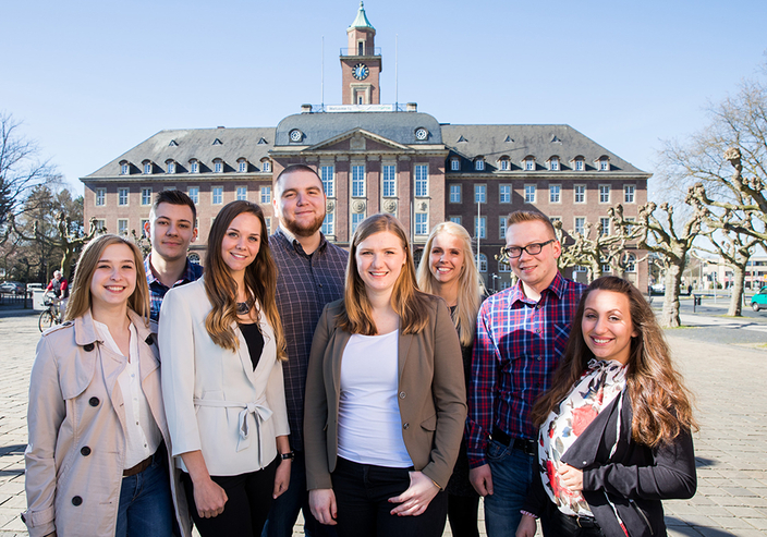 Gruppenfoto von acht lächelnden Auszubildenden vor dem Rathaus Gruppenfoto von acht lächelnden Auszubildenden vor dem Rathaus