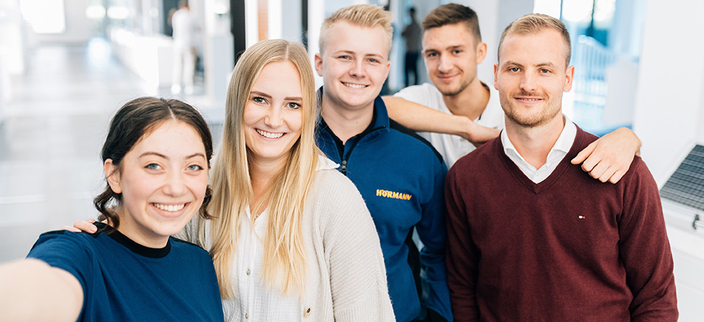 Fünf Personen lächeln in die Kamera. Fünf Personen lächeln in die Kamera.