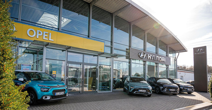 Gebäude Autohaus Nau. An der Glasfassade sind Schilder mit den Marken Opel und Hyundai angebracht.