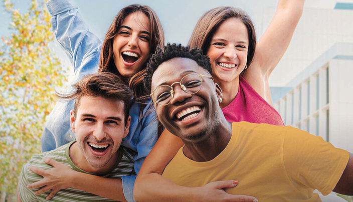 Vier junge Menschen lachen in die Kamera
